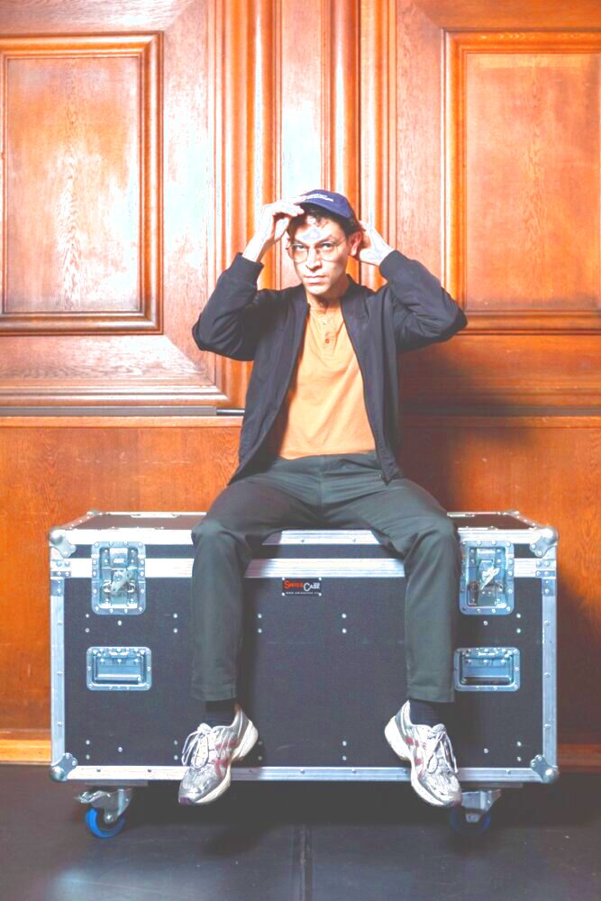 Andreas Eduardo Frank auf einem Flightcase sitzend.